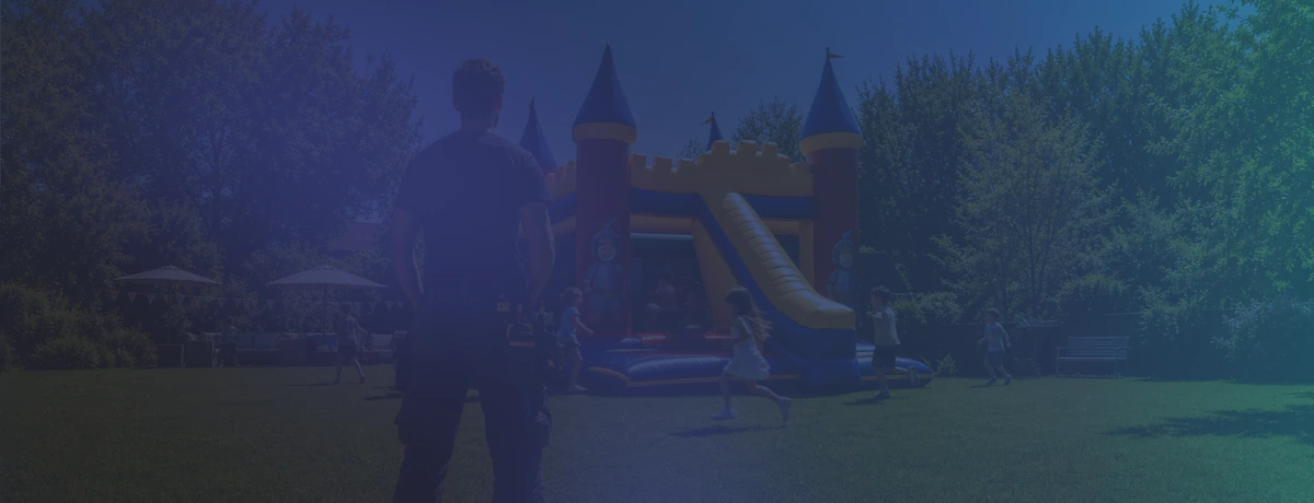Un jardin avec des enfants qui jouent sur un château gonflable.